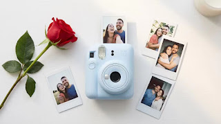 Fujifilm Instax Mini 12 camera with instant photos and a rose for Valentine's Day gift.
