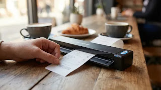 Ricoh ScanSnap iX100 wireless portable scanner digitizing a receipt on a coffee table.