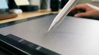 Writing on iPad with paper-feel screen protector to improve handwriting for college notes.