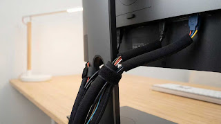 Neoprene cable sleeve organizing monitor cables on a gaming desk.