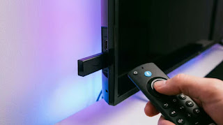Amazon Fire TV Stick 4K Max plugged into HDMI port with ambient backlighting for high-speed Super Bowl streaming setup 2026.