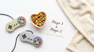 Valentine's Day gamer gift ideas with controllers and candy flat lay.