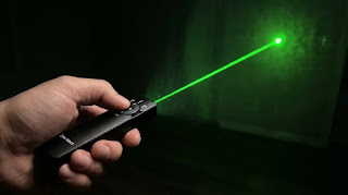Olight Arkfeld Pro flat EDC flashlight demonstrating the green laser pointer function.