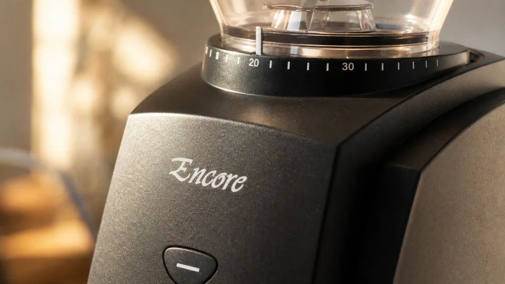Close up detail of the heavy duty grind adjustment dial and side toggle switch on the Baratza Encore burr grinder.