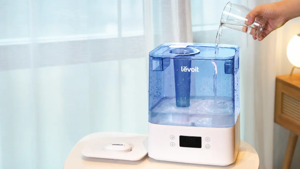 Pouring water straight into the top lid opening of the LEVOIT Classic 300S humidifier without removing the tank.