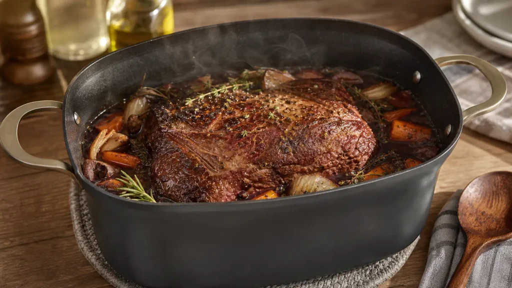 Searing beef short ribs directly in the aluminum cooking pot of the Ninja PossibleCooker PRO with steam rising
