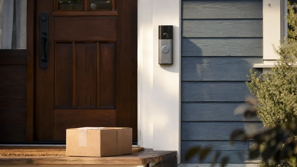 Ring Battery Doorbell 2K mounted beside a front door with a package on the porch